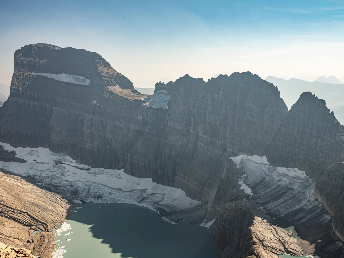 a mountain glacier with a lake and mountains behind