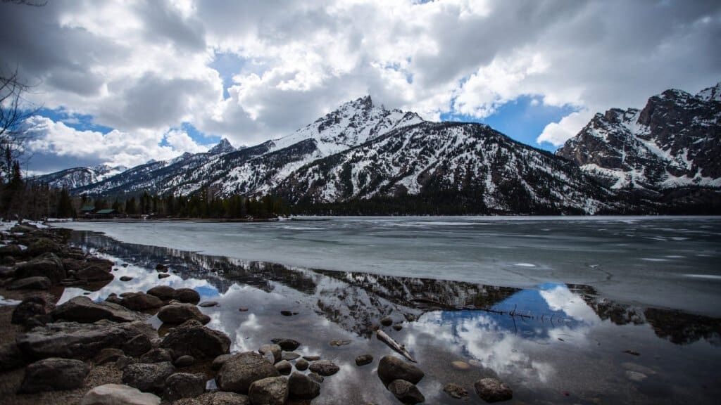 Jenny Lake in early spring with snow-capped Teton peaks reflected in calm water