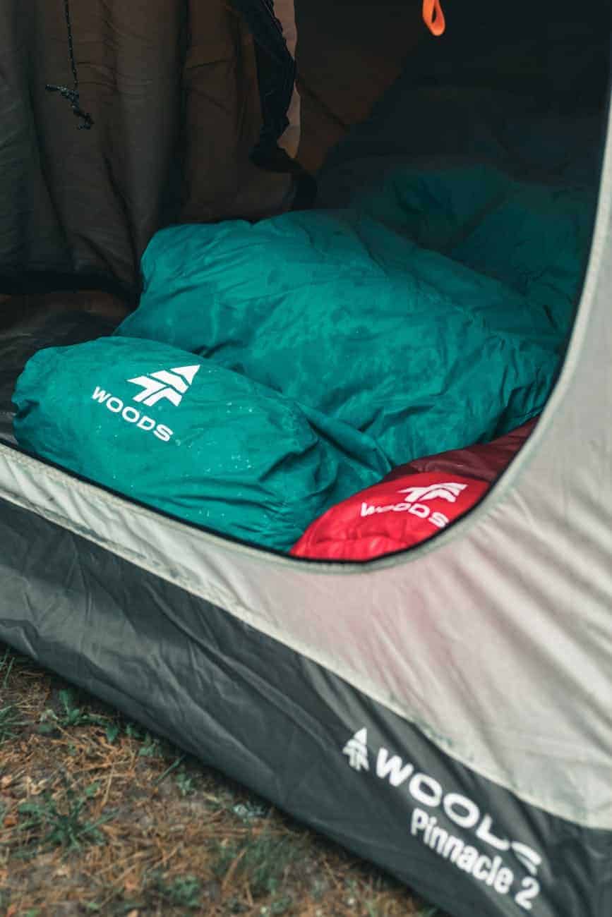 green and red wet ultralight sleeping bag in a tent