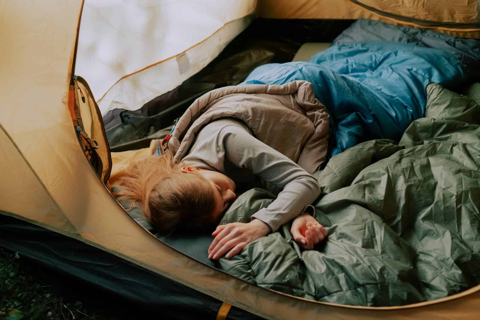 woman in sleeping bag inside a tent