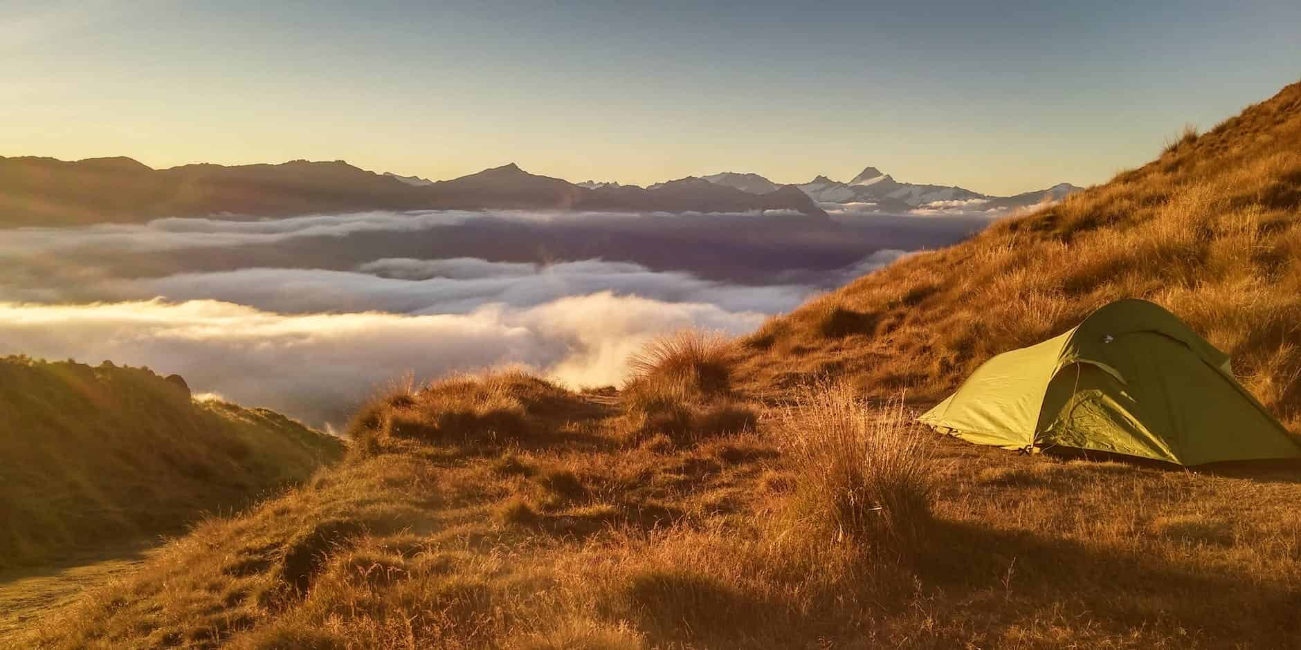 green tent on top of mountain with ultralight sleeping bag