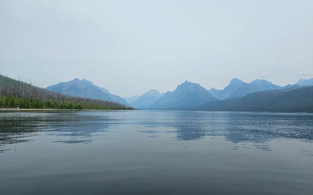 "Serene Lake McDonald with distant mountains in Glacier National Park.
