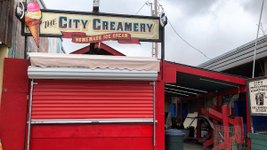 Exterior storefront with a colorful awning and chalkboard menu