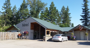 Motel building with a green roof and stone-front entrance in Glacier National Park.
