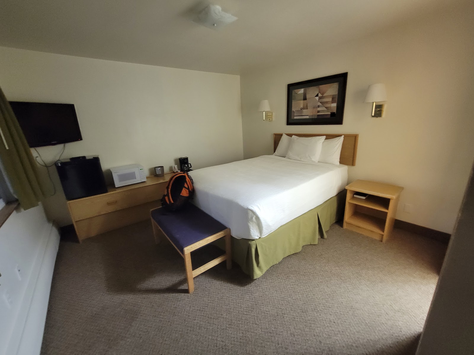 Cozy Glacier Inn Motel guest room in Glacier National Park with a queen bed and neutral decor.