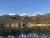 Lake Blaine in Glacier National Park reflects snow‑capped peaks and evergreen forests on a calm morning.