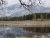 Lake Blaine reflects snow-dusted mountains and autumnal pines in Glacier National Park.