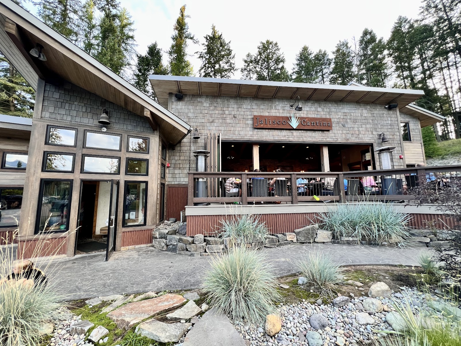 Glacier National Park restaurant building with outdoor seating and wood accents in a forested setting.