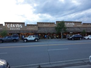 Exterior view of a rustic storefront with wagon-wheel accents and warm lighting