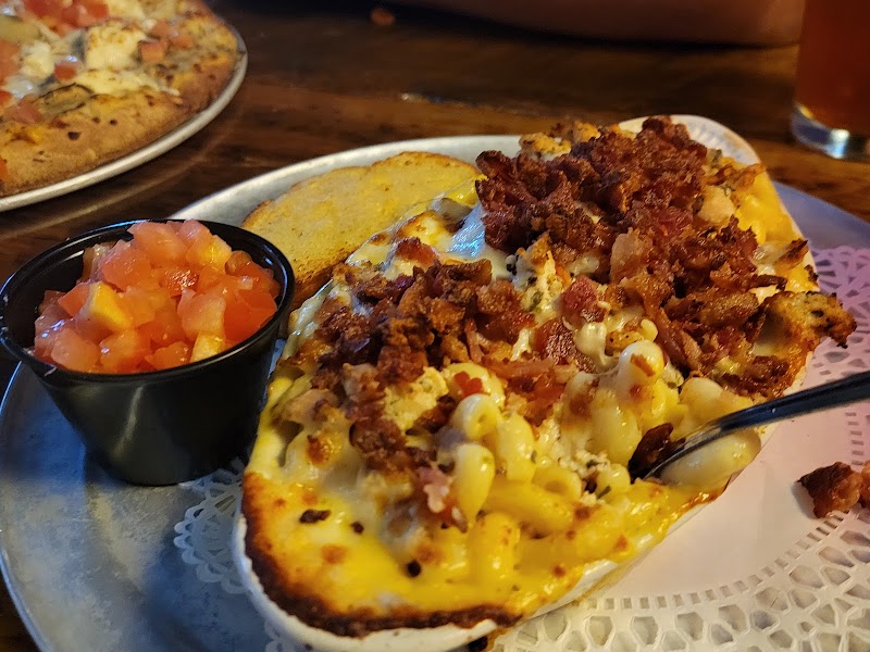 Cheesy loaded open-faced sandwich with bacon bits, corn and peppers on a toasted bun, side pico, in Yellowstone National Park.