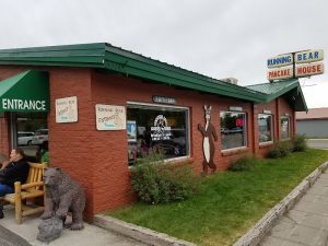 Rustic wooden facade with bear-themed sign and large front window
