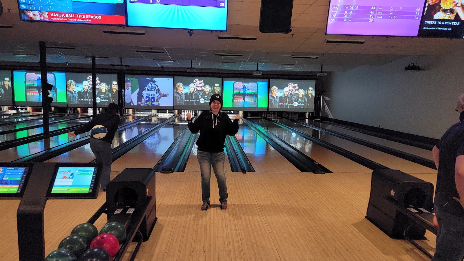 Indoor bowling lanes inside Glacier National Park at a casual entertainment venue, with glowing screens overhead and players in action.