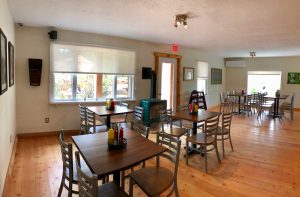 Interior dining area in Glacier National Park, a cozy lodge-style restaurant with wood floors.