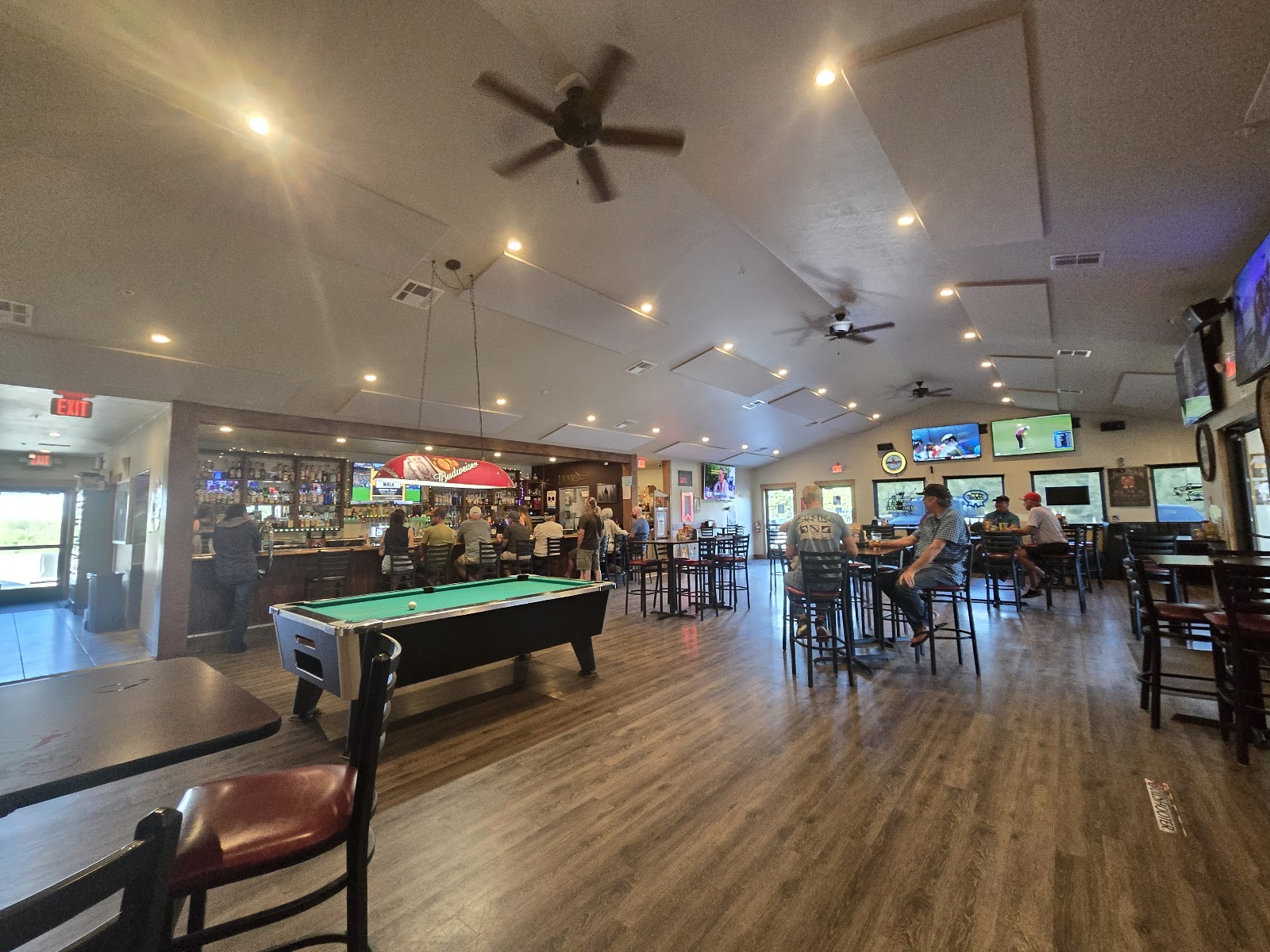 Midway Tavern interior in Glacier National Park, a bustling bar and billiards hall with TVs.