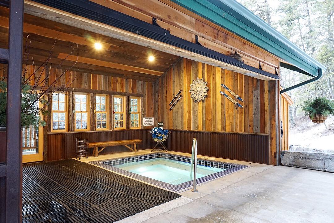 Indoor pool at a Glacier National Park lodge, warm wood walls and cozy seating in a covered courtyard.