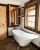 Rustic lodge bathroom in Glacier National Park featuring a porcelain clawfoot tub and dark wood trim.