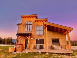 Rustic timber lodge at a guest ranch near Glacier National Park, bathed in warm sunset light.