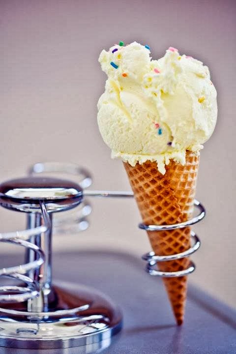 Vanilla ice cream cone with rainbow sprinkles resting on a chrome display stand in Glacier National Park.