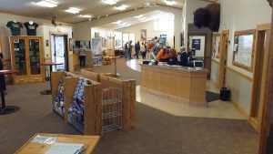 Exterior view of a visitor information center storefront with a wooden sign and large windows