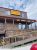 Rustic gift shopfront in Gardiner, Yellowstone National Park, featuring wooden railing and log architecture.