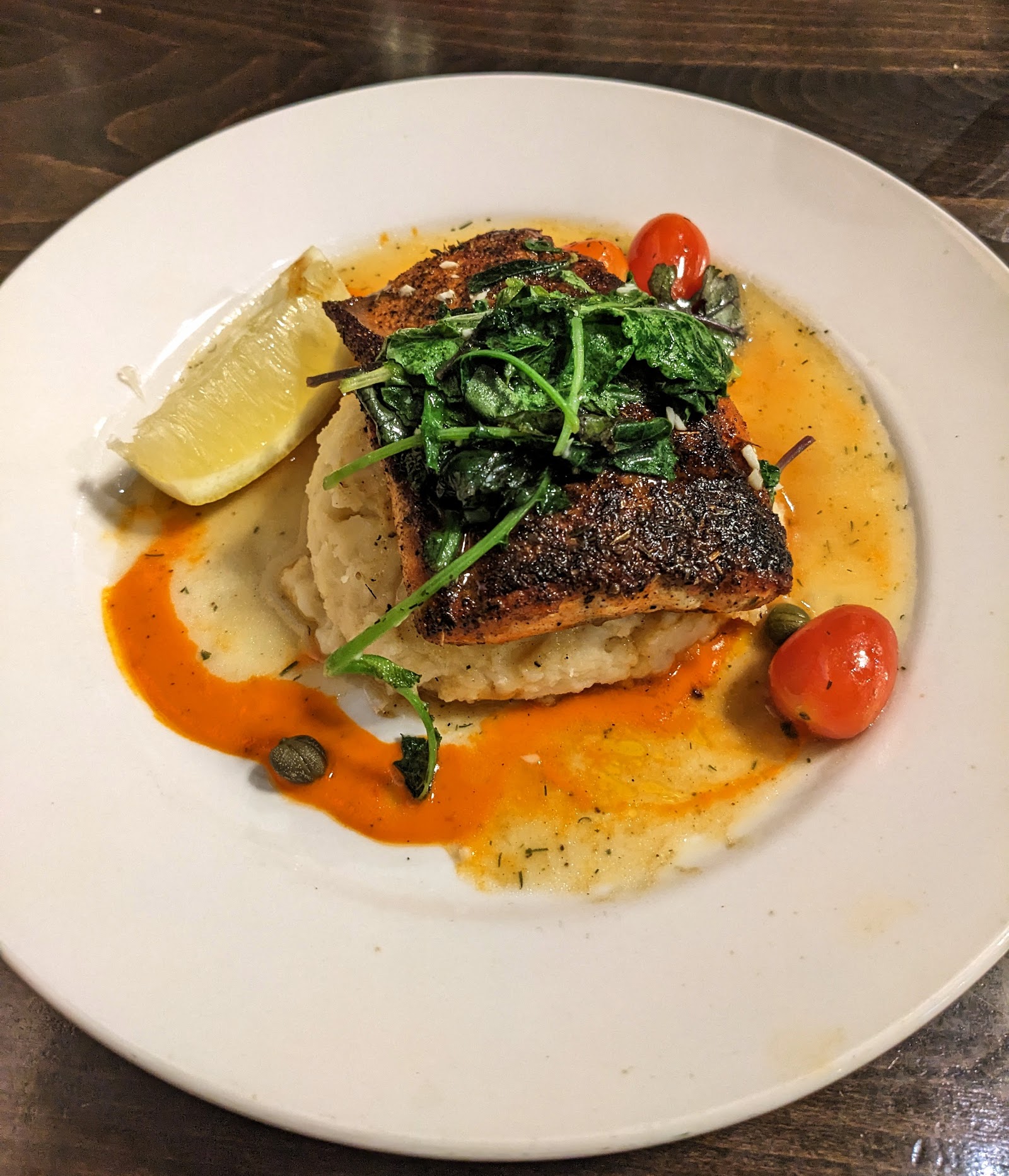 Crispy-skinned seared fish over creamy mashed potatoes with greens and orange sauce at Glacier National Park’s Meadow Lake area.