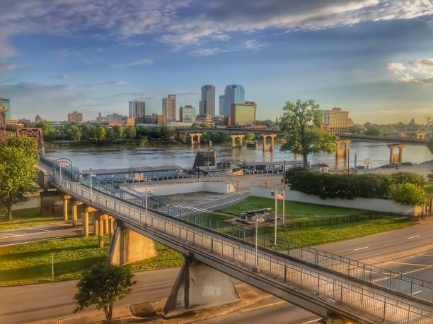 Parke Peak overlook in Glacier National Park with a river, bridge, and city skyline in the distance during a sunny afternoon.