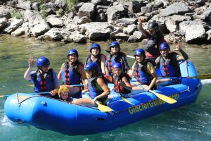 Group rafting on the Flathead River in Glacier National Park, Montana, with helmets and life jackets.