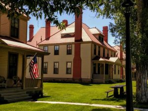Fort Yellowstone Visitor Center at Yellowstone National Park sits among red-roofed clapboard buildings with flags out front.