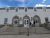 Fort Yellowstone Visitor Center at Yellowstone National Park greets visitors with arched stone entries and a white facade under a blue sky.