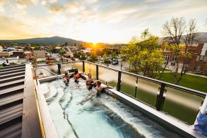Rooftop hot tub at a Whitefish, Montana lodging with sunset over Glacier National Park foothills.