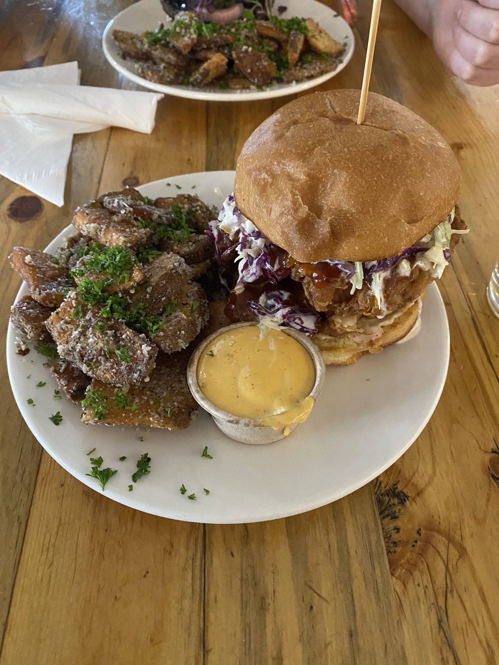 Crispy fried chicken sandwich with purple coleslaw and dipping sauce served with herb potatoes at a Glacier National Park restaurant.