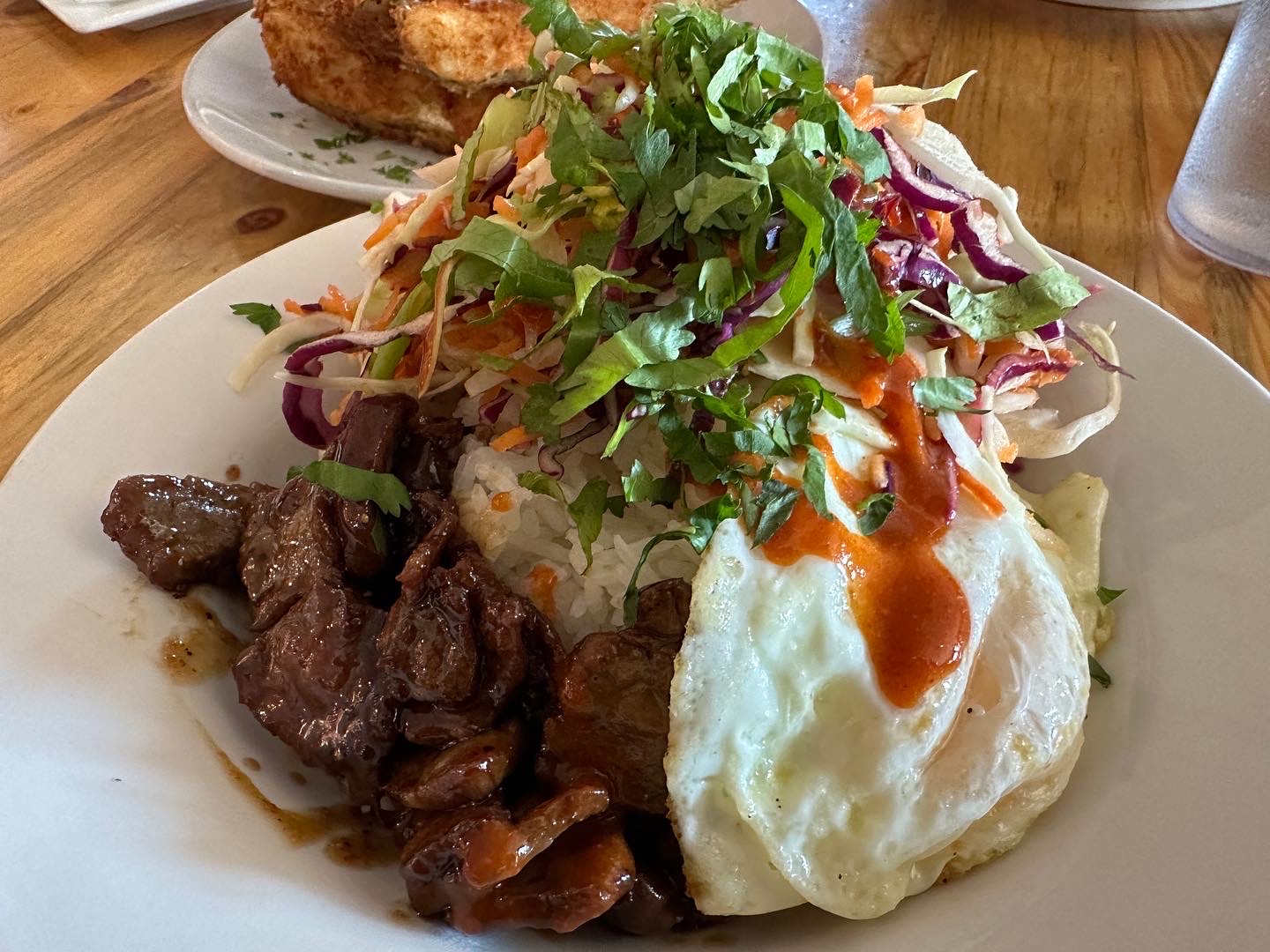 Meal of beef steak, fried egg, rice, and colorful slaw served at a Glacier National Park dining spot.