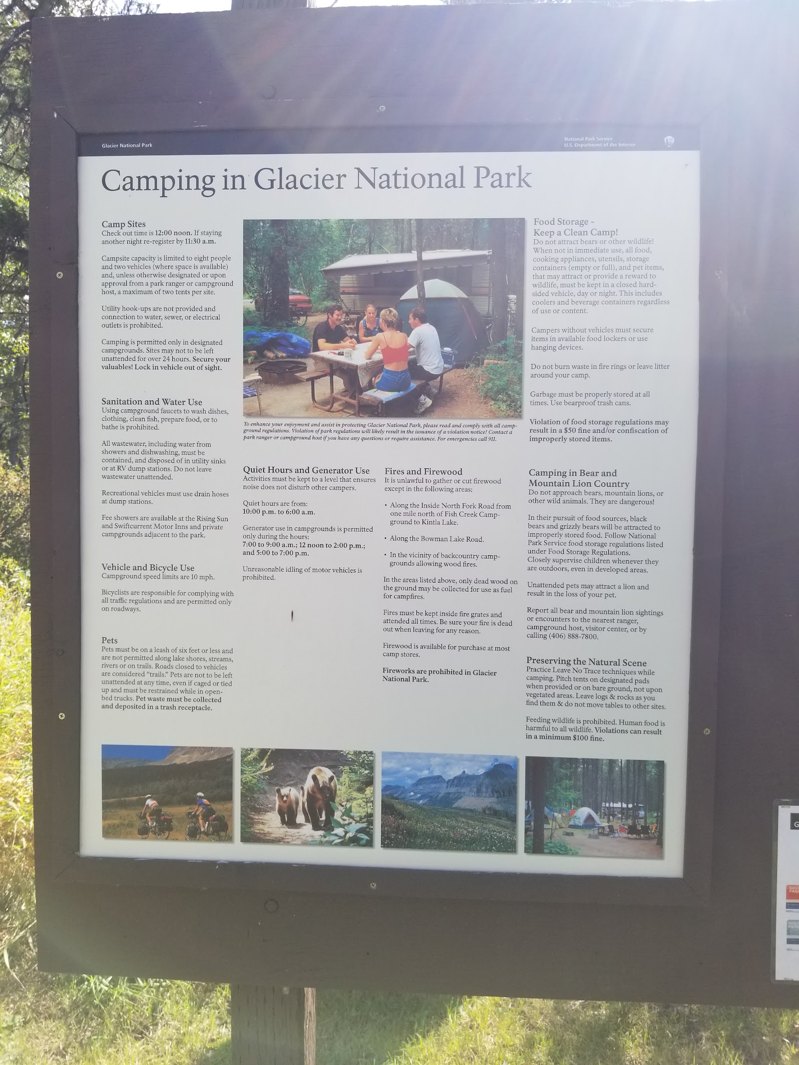 Large wooden information board titled Camping in Glacier National Park, with text panels, a central photo of campers, and small bottom pictures.