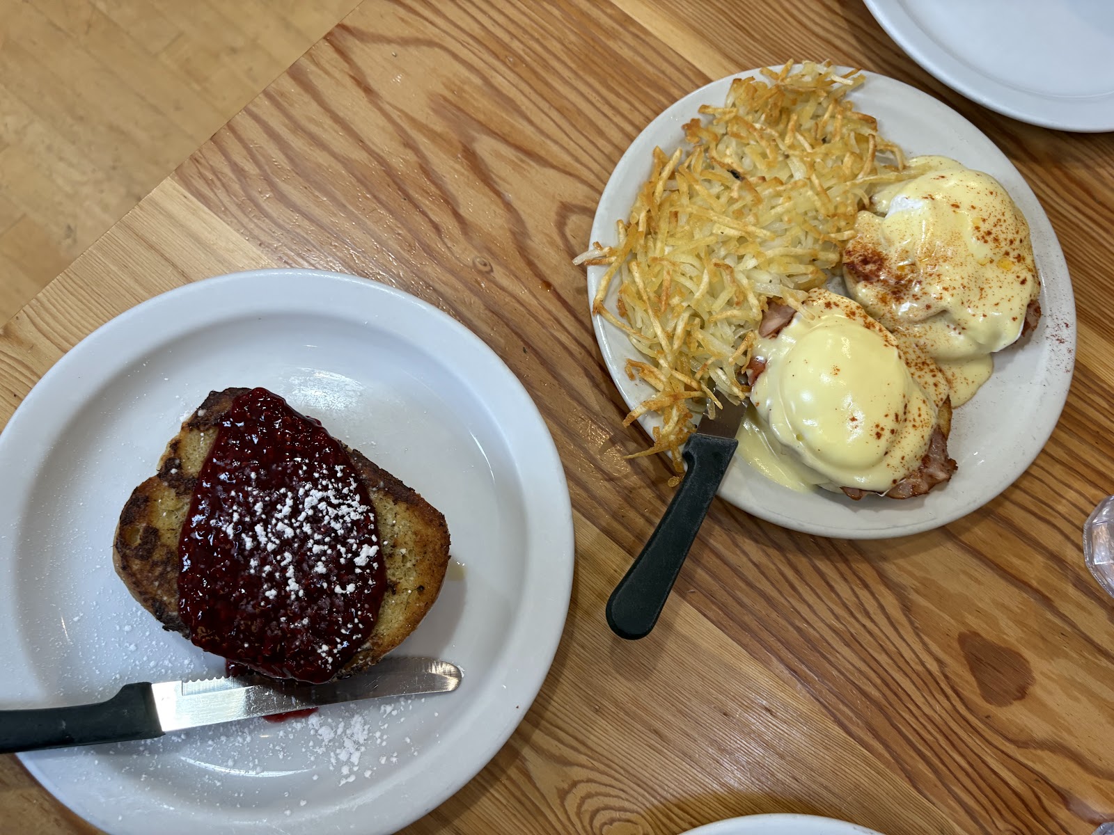 Breakfast at Glacier National Park featuring eggs Benedict with hollandaise and a side of crispy hash browns.