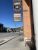 Signage for a neighborhood cafe on a brick building along a Glacier National Park gateway street, under a clear blue sky.
