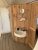 Rustic wooden bathroom in Glacier National Park tent lodge, white sink, round mirror, towel, and shower area.