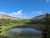 Imperial Geyser area in Yellowstone National Park shown from a scenic overlook with a small pool and pine hills.