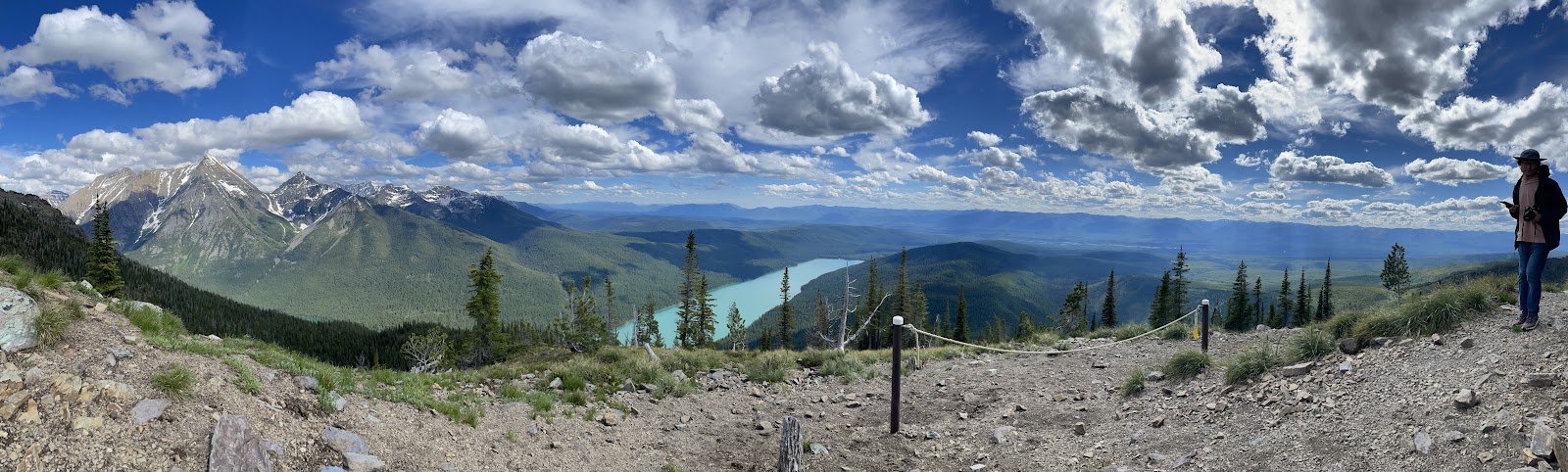 Numa Peak overlook in Glacier National Park reveals a sweeping alpine panorama with jagged peaks and a turquoise lake.