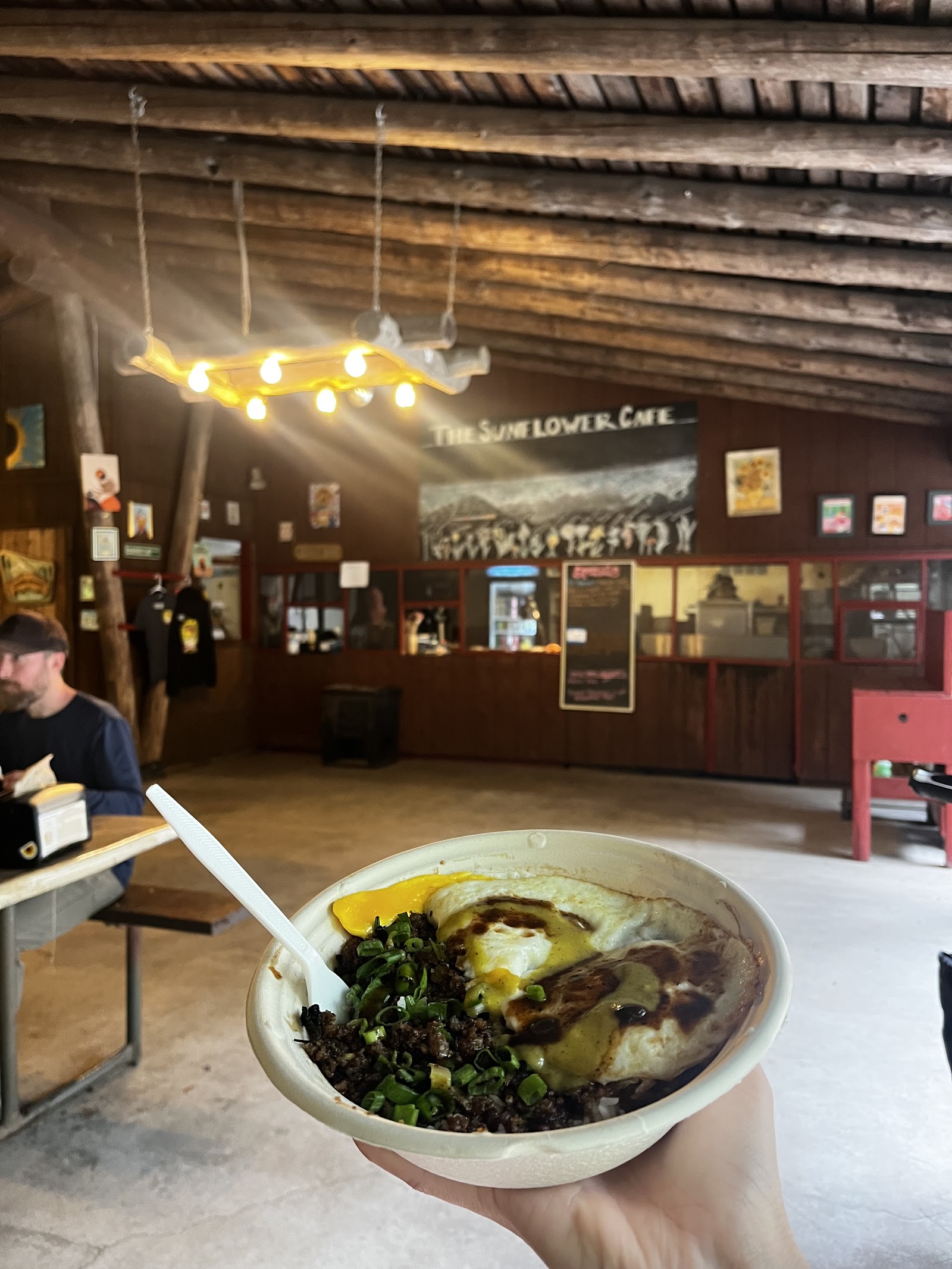 Interior at Sunflower Cafe & BBQ in Glacier National Park, rustic lodge-style dining with a bowl of food in the foreground.