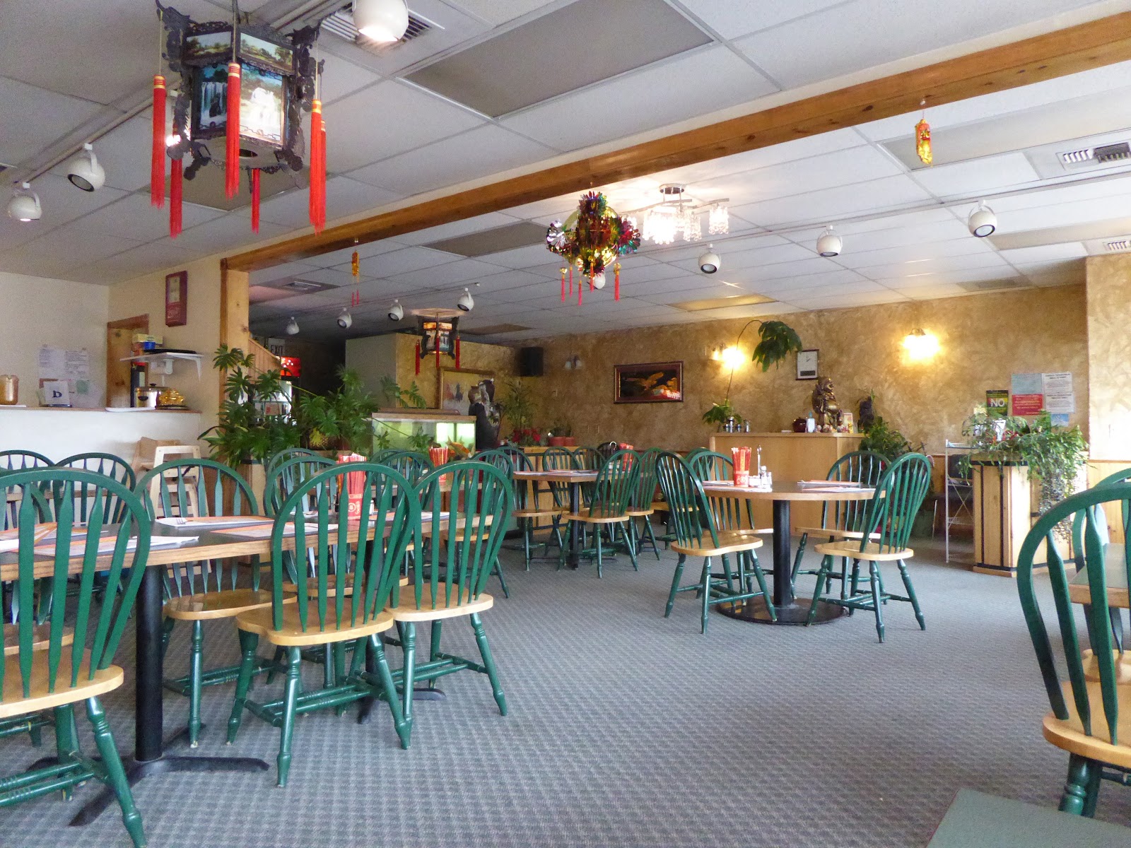 Interior of a Glacier National Park dining area with green curved-back chairs and festive decor.