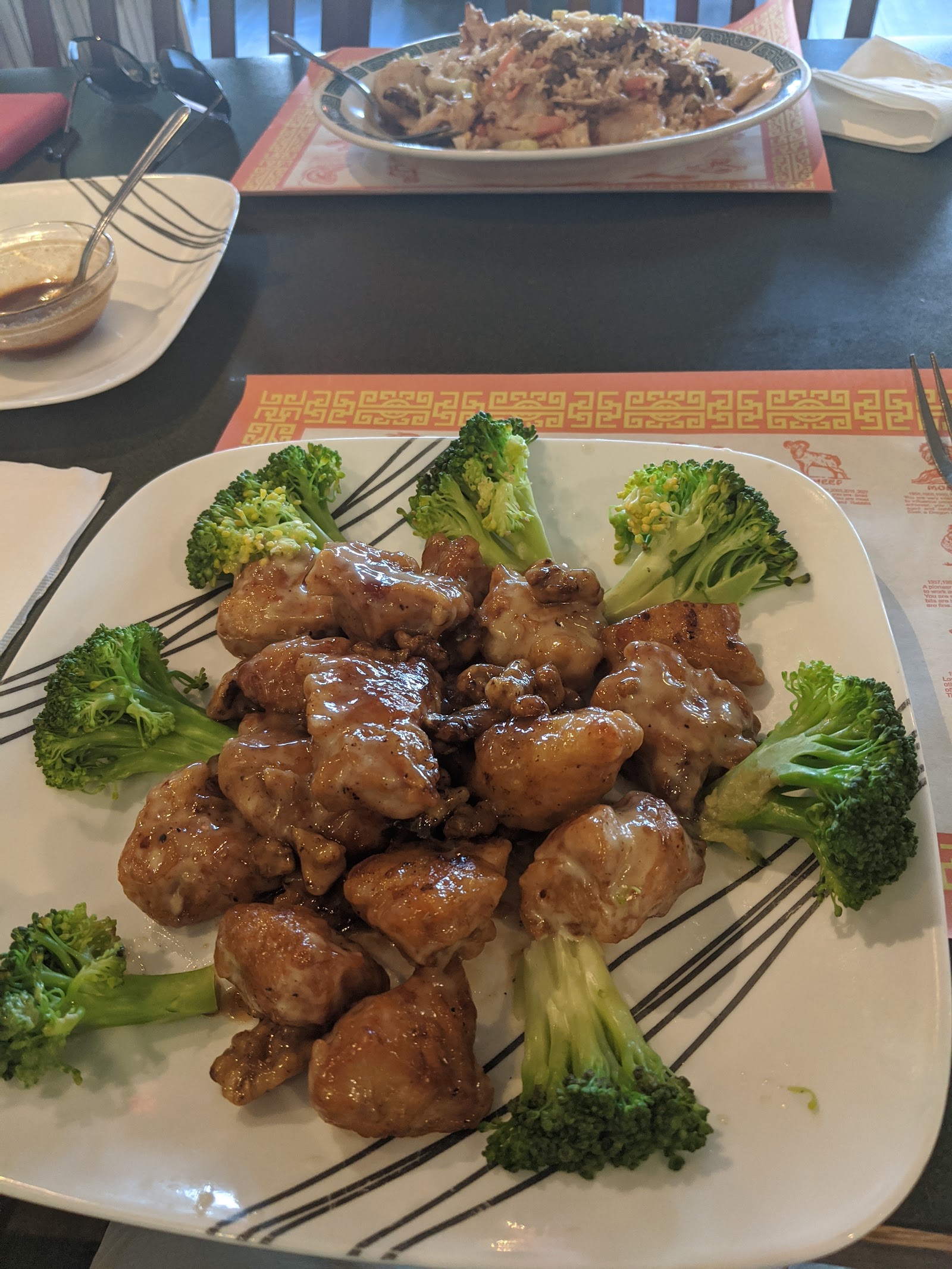Glazed chicken bites with broccoli arranged on a white plate at Glacier National Park dining spot.