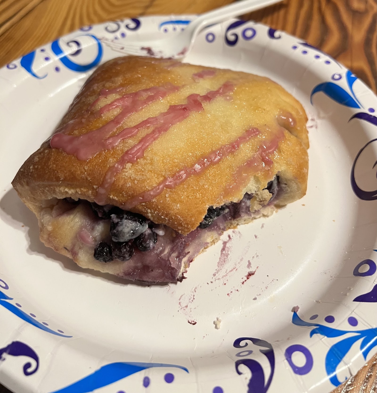 Blueberry pastry with pink glaze sits on a disposable plate in the Polebridge area of Glacier National Park.