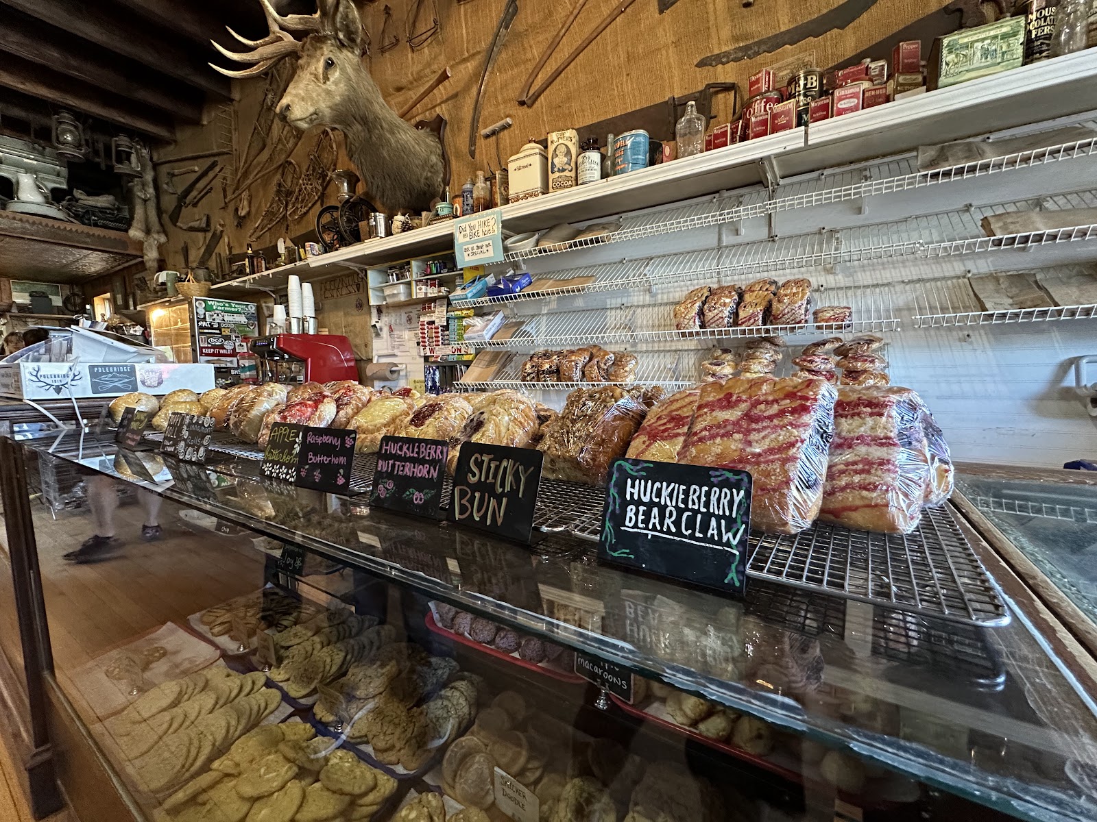 Inside a rustic Glacier National Park storefront near Polebridge, pastries line a glass display in a cozy bakery setting.
