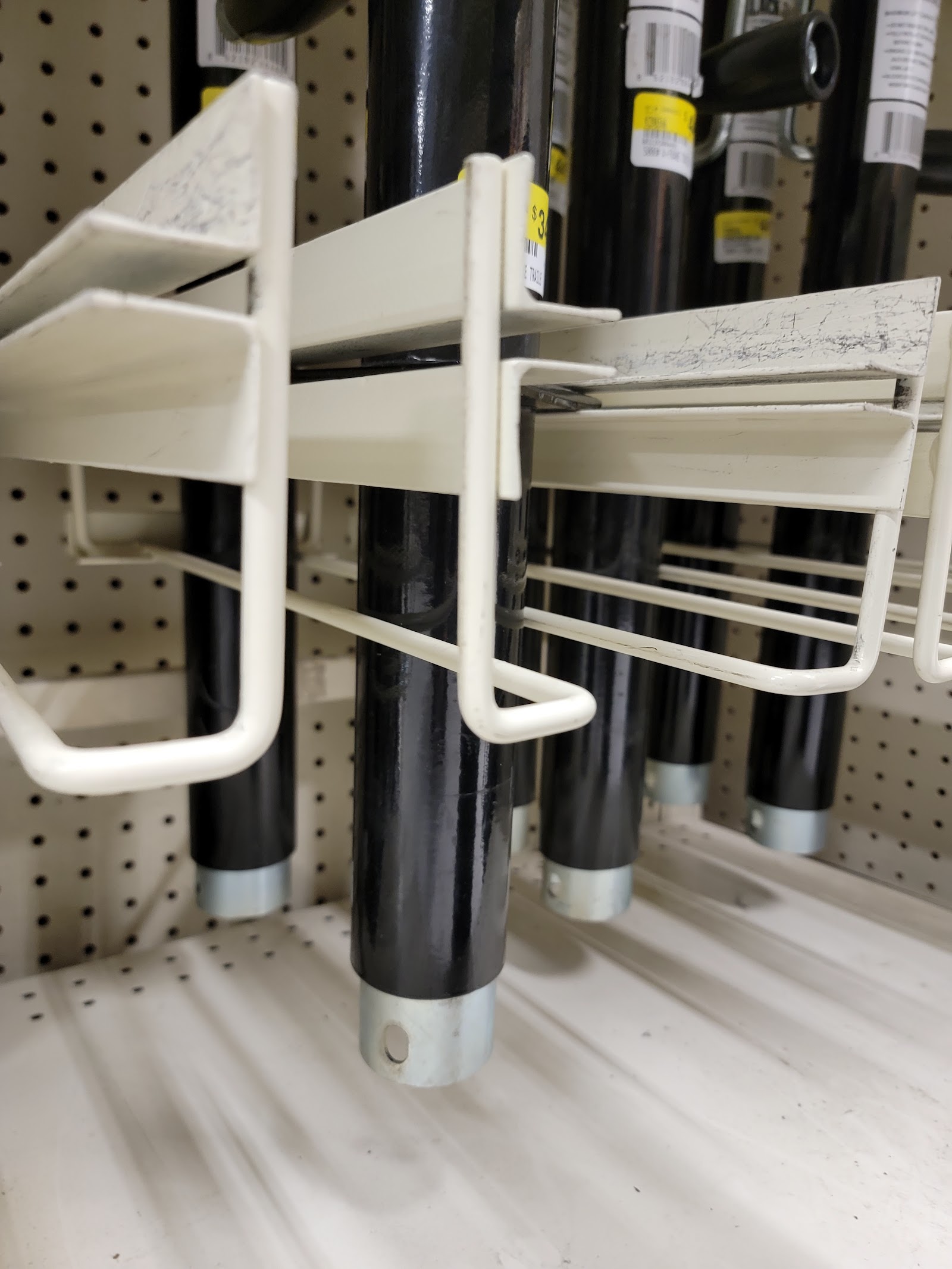 Hiking poles displayed on a peg rack inside a Glacier National Park gift shop aisle near the front.