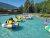 Bumper boats operate in a shallow pool at the Glacier National Park recreation area with colorful rounds and a water feature.