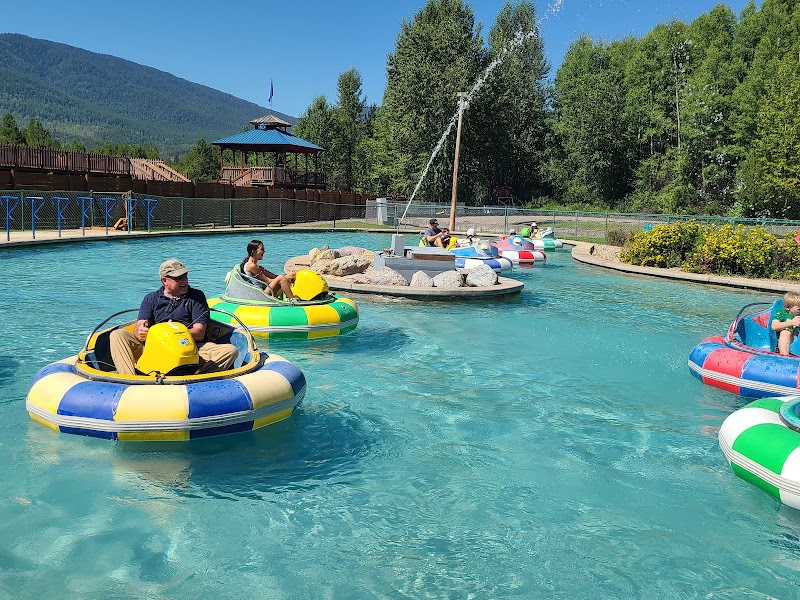 Bumper boats operate in a shallow pool at the Glacier National Park recreation area with colorful rounds and a water feature.
