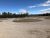Gravel campground loops and gravel roads wind through Glacier National Park with pine trees and distant mountains under a blue sky.
