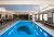 Indoor pool at a lodge in Yellowstone National Park, with benches along the windows and a large pool logo.