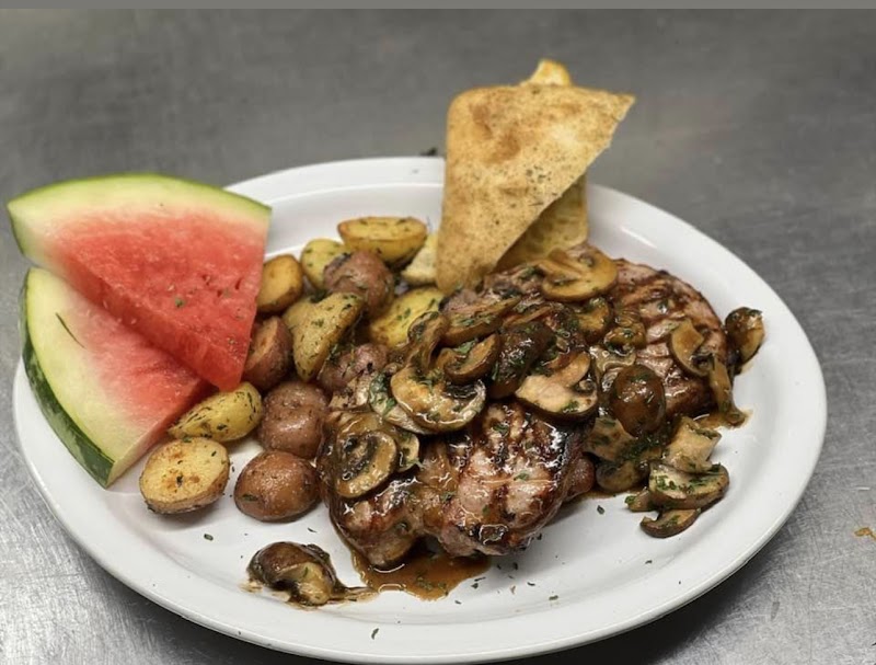 Plate with watermelon slices, roasted potatoes, sautéed mushrooms, and grilled meat with a tortilla wedge in Yellowstone.