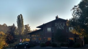 Lodge exterior at Glacier National Park, a wooden building with large windows glowing in autumn light.